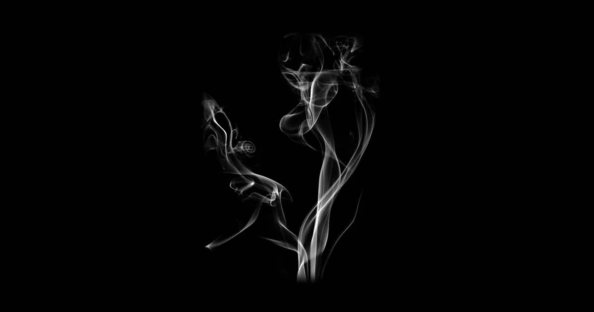 黒背景に立ち上る白い煙の写真